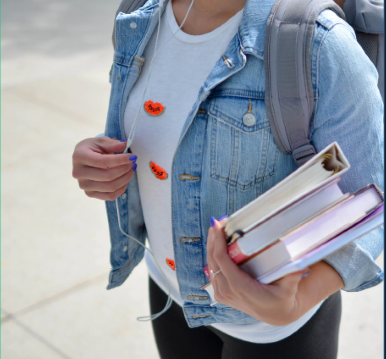 Estudiante sosteniendo libros de texto en el campus